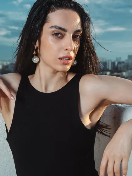 The combination of dewy skin, brushed-up brows, and wet-look hair creates a powerful, modern look. The makeup is designed to look fresh and radiant even in bright, outdoor conditions.