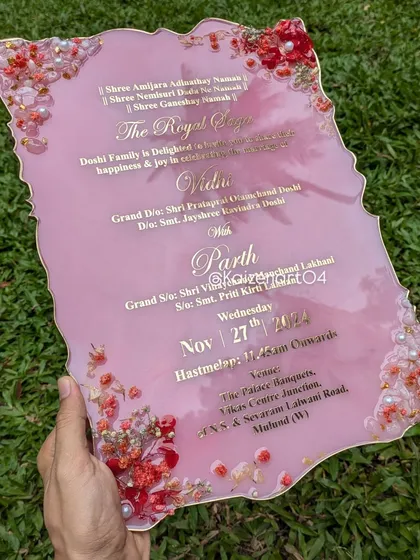 Another look at the pink agate-style resin invitation, held up to show its size and the beautiful way the light catches the gold lettering.