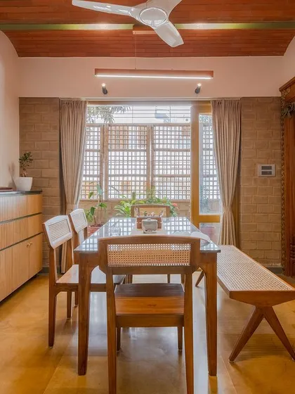 The full dining space, showing the custom furniture and natural material palette.