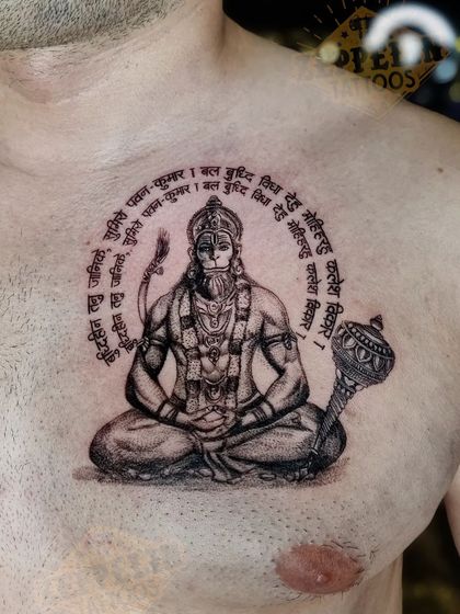 A detailed chest tattoo of Lord Hanuman, encircled by the Hanuman Chalisa. This piece required precise script work and a focus on a powerful, meditative expression.