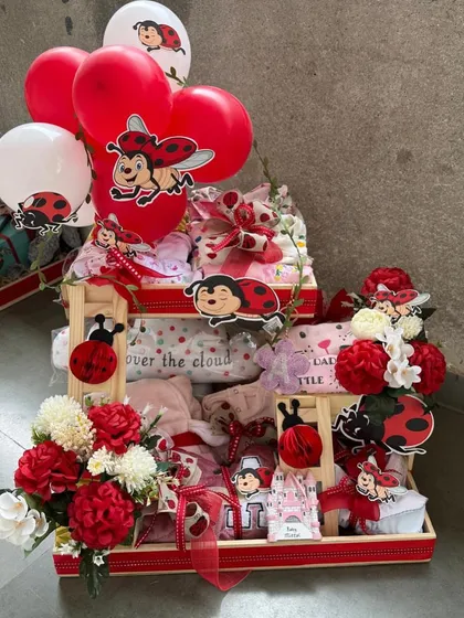 A grand, multi-level ladybug-themed hamper, complete with festive balloons. This impressive arrangement is perfect for making a big statement at a baby shower or as a hospital welcome gift.