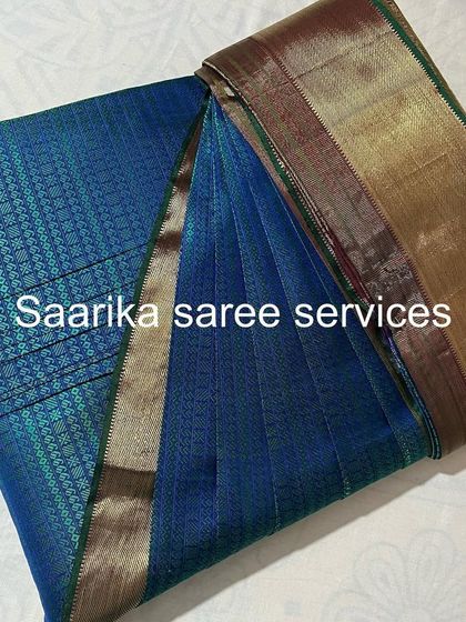 A beautiful blue silk saree with a bronze border, showing the final result of my box folding service.