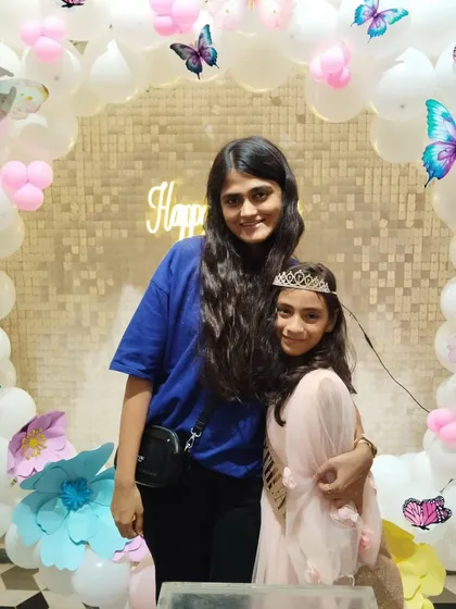 A sweet moment between sisters at a birthday party.