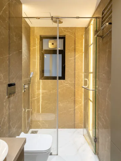 A different view of our bathroom wrapped in warm taupe and caramel-toned marble. The vertical lighting and glass partition create a sense of separation without sacrificing the open, luxurious feel of the space.