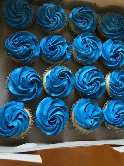 A box of classic blue frosted cupcakes, perfect for a "it's a boy" baby shower or a blue-themed birthday party. The simple rosette piping is elegant and timeless.