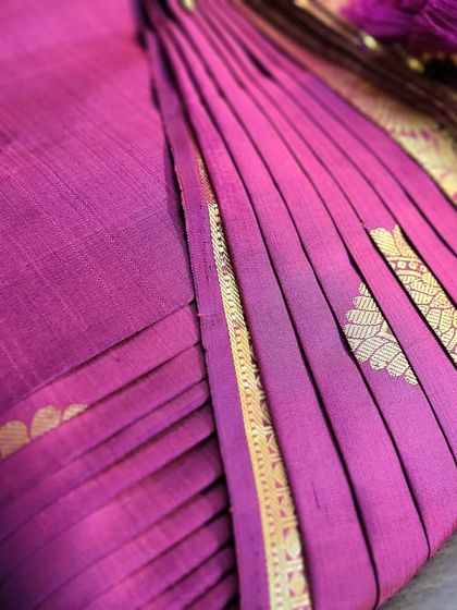 A close-up of the beautiful pleats and tassels on the magenta saree.