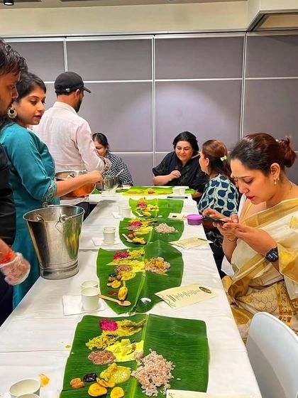 Guests enjoying a traditional Onam Sadhya, served on banana leaves. I can cater this experience for residential complexes or private parties, ensuring an authentic celebration.