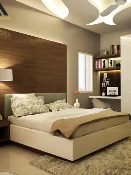 A render of a serene and modern bedroom design. This space features a beautiful wood-paneled accent wall with integrated backlighting, a dedicated study nook, and a unique false ceiling design, creating a calm and functional retreat.