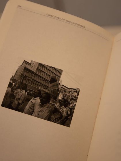 A page from the 'Directory of the Outsiders' book, combining text and image to tell a powerful story.