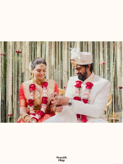 A close-up of the ring exchange during a South Indian wedding ceremony, a simple yet profound symbol of their commitment.