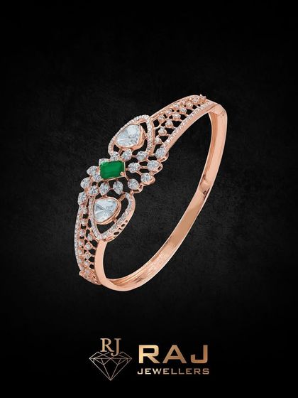 This elegant rose gold bracelet features a central green stone flanked by heart-shaped motifs. The delicate design is both romantic and modern.