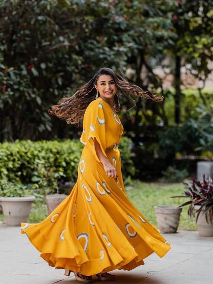 A candid, twirling shot that captures the fun of a Haldi ceremony. The makeup is designed to look flawless even in motion, with a focus on radiant, happy skin.