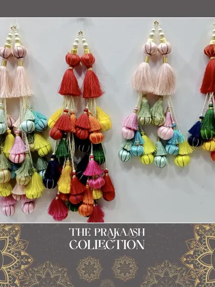 A vibrant collection of multi-layered ethnic tassels, or latkans, in a rainbow of colors. These are ideal for adding a festive and traditional pop to lehenga ties, blouse backs, or dupattas.