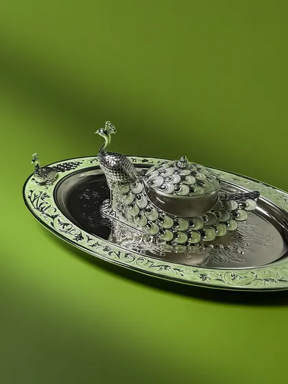 Perfect for festive tables, this white enamel peacock dry fruit box comes with a matching oval tray. The set is as functional as it is eye-catching.