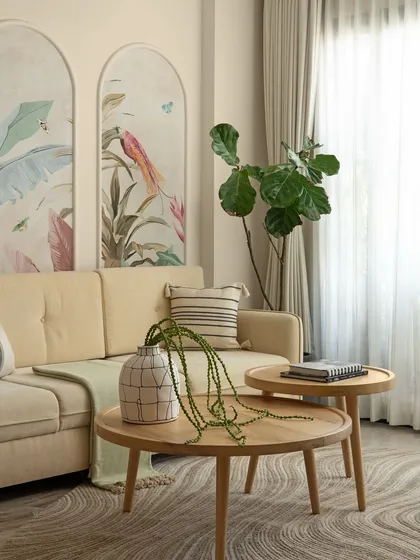 Detail of the coffee table styling, with a contemporary vase and cascading greenery. The wavy pattern of the rug below adds a sense of movement and rhythm to the calm space.