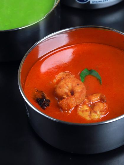 A close-up of our delicious Shrimp Curry, made with a rich, tangy tomato and coconut base. It's a coastal favorite that we love bringing to your tiffin.