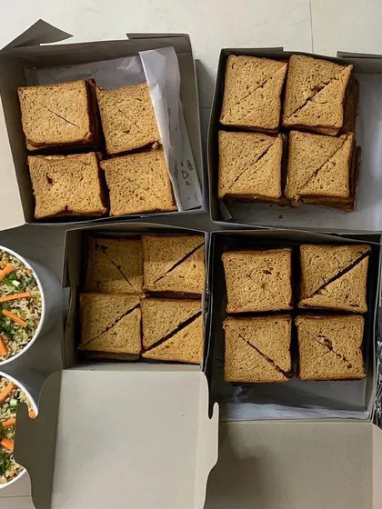 Packing up an order for a school picnic. Boxes of sandwiches and containers of fried rice, all ready for an early morning delivery.