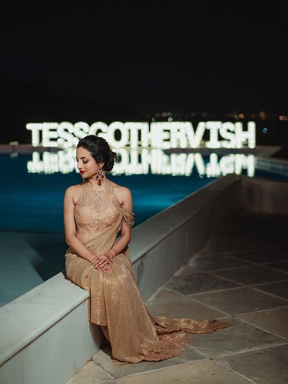A quiet moment for the bride. Even in repose, her bold red lip and shimmering makeup exude pure elegance and glamour.