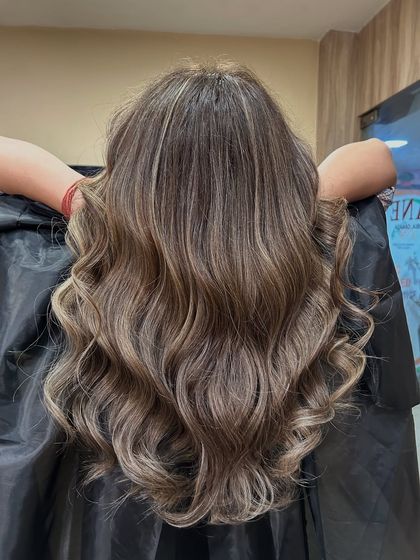 The beautiful result of a Beige Ash hair color, styled into soft, flowing waves to showcase the dimension and tone.