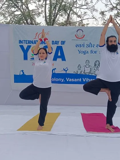 Two of our lead instructors demonstrate Vrikshasana (Tree Pose) on stage during an International Yoga Day event. Their balance and poise serve as an inspiration for all participants.