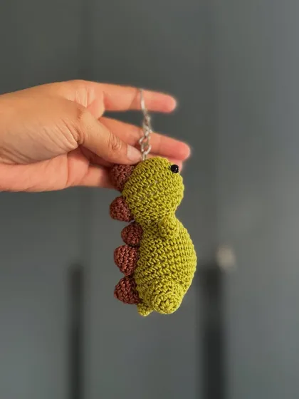 A tiny dinosaur keychain to guard your keys. This amigurumi dino is a fun and quirky accessory for all ages.