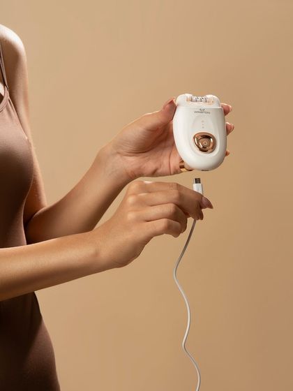 A detail shot showing the epilator being charged. This is a practical, utility-focused image that answers a potential customer question.