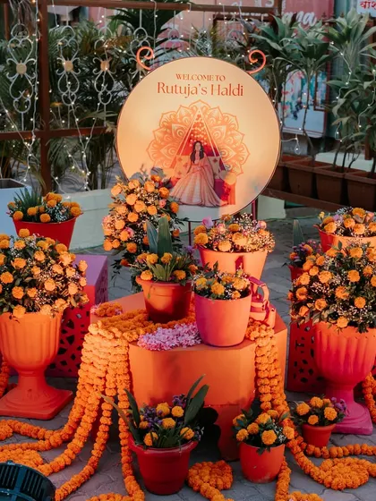 A welcome setup dedicated to the bride's Haldi. I used an abundance of bright orange marigolds and a custom-lit sign with a mandala design to create a warm and traditional entrance.
