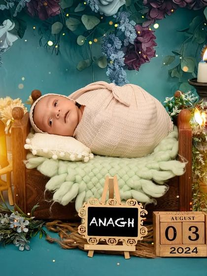 A newborn rests in a basket in a mystical, candlelit forest setting. This creative newborn setup uses deep colors and soft lighting to create a magical, fairy-tale feel.