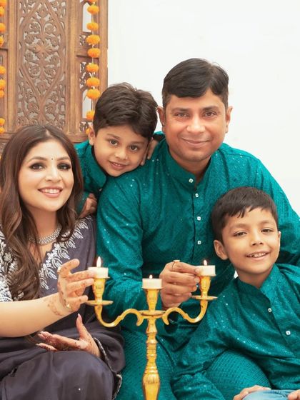 A happy family portrait during a Diwali themed shoot. The coordinated traditional outfits add to the festive and joyful atmosphere of the photograph.