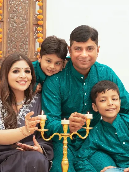 A happy family portrait during a Diwali themed shoot. The coordinated traditional outfits add to the festive and joyful atmosphere of the photograph.