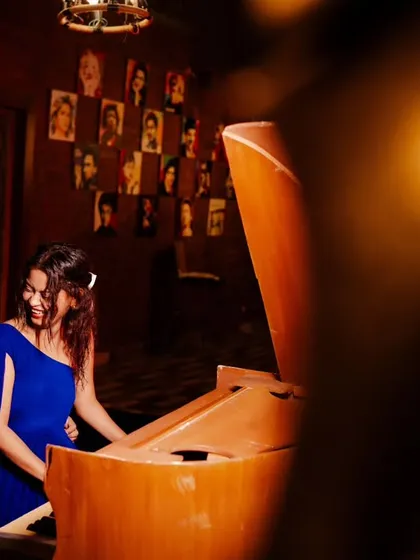 A different angle of the musical moment, capturing the bride's joyful reaction. The warm lighting and candid emotion make this a truly special pre-wedding photograph.