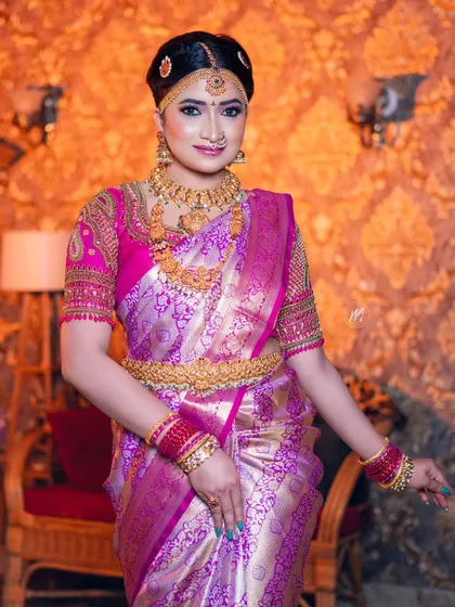 A full-length shot of the Telugu bride, showing the beautiful drape of her pink and gold silk saree.