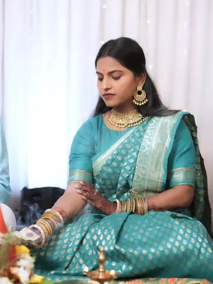 The bride-to-be participating in a pooja ceremony, her makeup looking elegant and appropriate for the occasion.