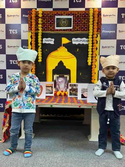 Two little boys with their heads covered, paying respect during our Gurpurab celebration. We create a special setup to teach them about Guru Nanak Dev Ji's teachings.