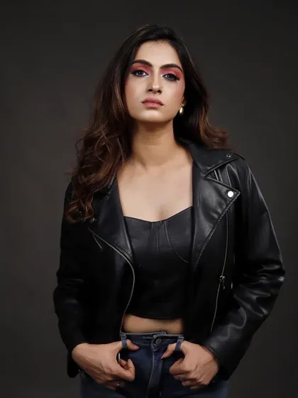 A direct, front-facing portrait of the model in a leather jacket, conveying strength and attitude.