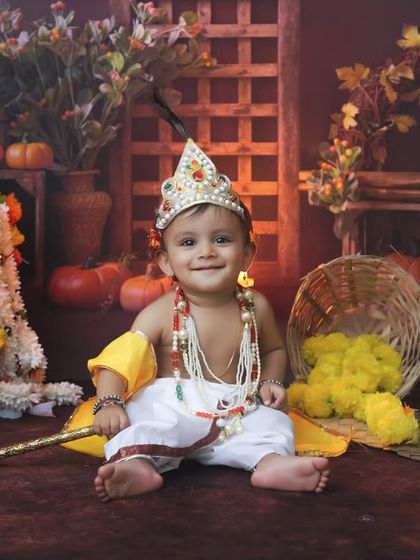 This little boy is perfectly styled as Krishna, looking curious and sweet. Our traditional photoshoots are a wonderful way to celebrate festivals and cultural heritage.