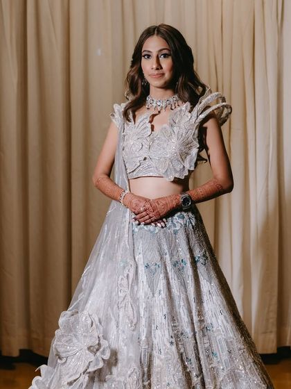 My bride Ria looking ethereal in a structured silver and blue lehenga for her Sangeet. The makeup is kept soft and shimmery to complement the futuristic vibe of the outfit.