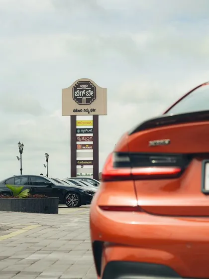 A focused shot on the rear of an orange BMW, with our tall brand pylon in the background, capturing the modern and automotive-centric vibe of our location.