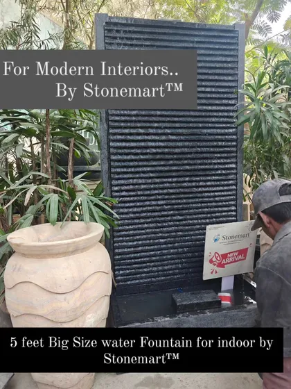 An artisan inspects the 5-foot granite waterfall. This large piece is designed for modern decor in homes, gardens, and commercial establishments.