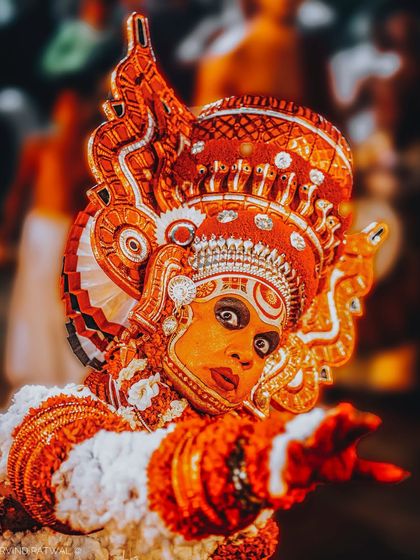 A Theyyam artist from Kerala, captured mid-performance. The intricate makeup and elaborate costume transform a human face into a divine entity, showcasing a rich cultural art form.