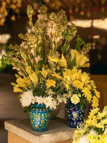 A beautiful arrangement of yellow lilies and tuberoses in traditional blue pottery vases, a perfect fusion of colors and cultures.