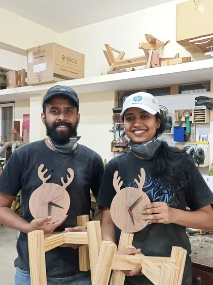 Arjun and Ann with the reindeer-themed clocks and planter stands they made. They learned to use a variety of power tools, including the jigsaw, circular saw, and router.