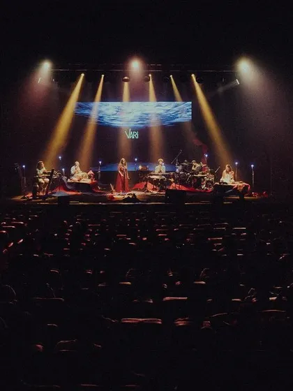 A wide shot of the stage during the 'Vari' album release concert. This shows the entire ensemble, seated and ready to create a magical night of music for a packed auditorium.