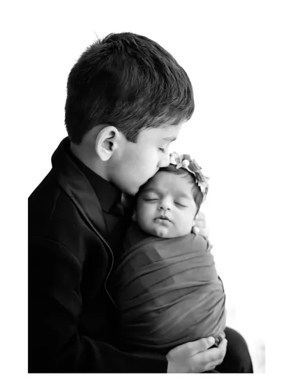 Capturing the gentle bond between siblings is a special part of our family sessions. We guide older siblings on how to hold their new brother or sister safely for a touching and memorable photograph.