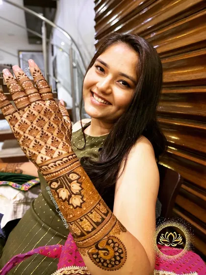 A beautiful backhand design for an engagement, featuring floral bands and a peacock motif. The bride-to-be's smile makes the art even more beautiful.