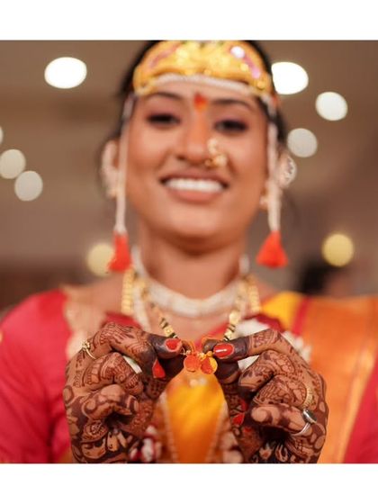 A close-up of the bride's hands during a wedding ritual, highlighting the intricate details of the ceremony.
