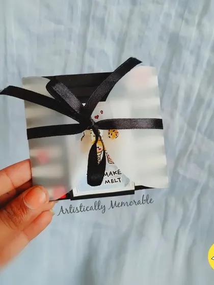 A close-up of the small, ribbon-tied interactive card, a perfect little surprise.