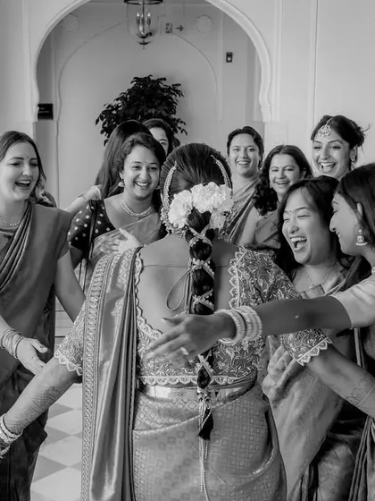 A heartwarming black and white shot of the bride being embraced by her emotional and happy bridesmaids.