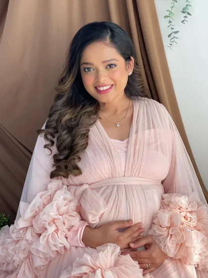A beautiful portrait of the mommy-to-be, her hair styled in soft curls to complete the angelic look.