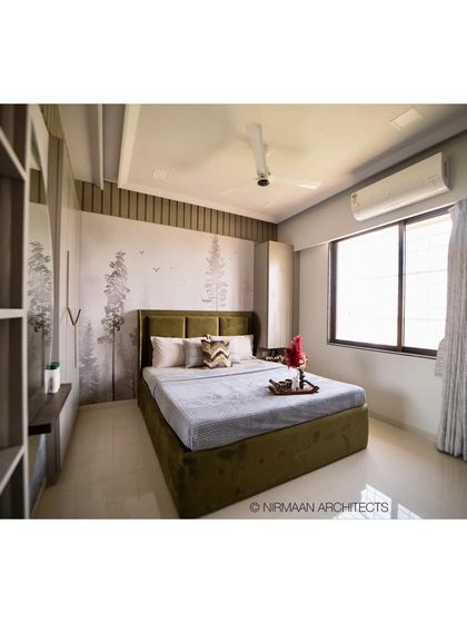 This master bedroom uses a serene, nature-inspired wallpaper to create a calming backdrop. The olive green bed and warm wood tones enhance the connection to nature.